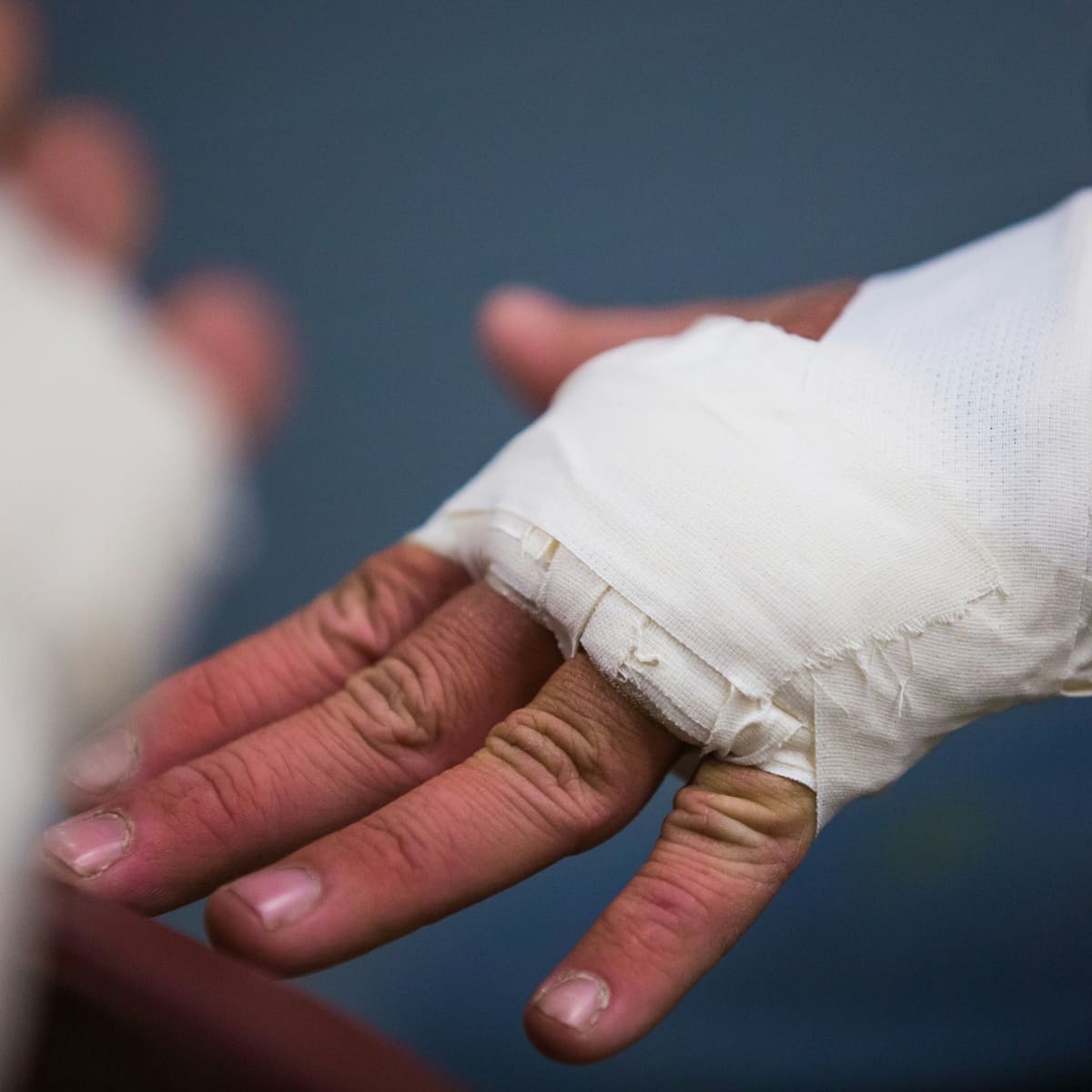 Wrapped injured hand preparing to return to training safely with an online personal trainer.