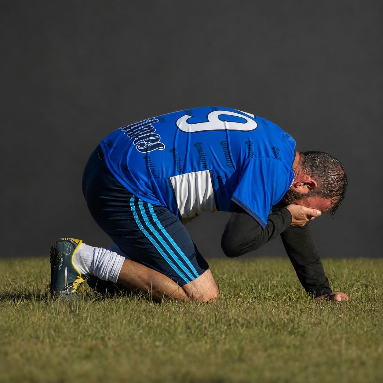Soccer player on knees in frustration, showing the pressure of starting at an old fitness level.